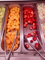 Fruit and salad bar items in a stainless steel pan