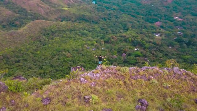 drone view with a person opening his arms enjoying the mountain in prado tolima colombia. concept of freedom and nature
