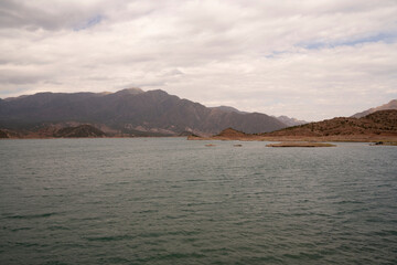 View of the reservoir in Potrerillos, Mendoza. The arid environment, turquoise glacier water lake and Andes mountains in the background.