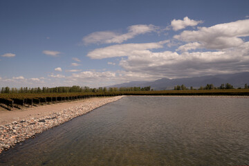 View of the artificial lake, vineyard and mountains in the horizon. 