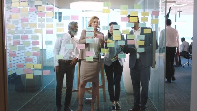 Teamwork collaboration, sticky note planning and window solution for ideas, vision and collaboration in modern office agency. Diversity business people thinking, working and innovation strategy notes
