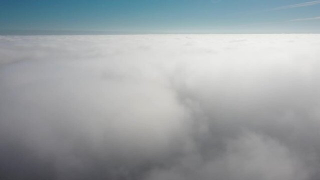Descending in clouds dive in, low sunlight above clouds