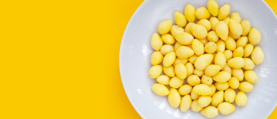 Boiled ginkgo nuts on yellow background.