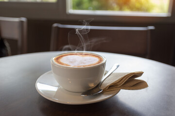 Coffee in White cup on wooden table in cafe with lighting background. coffee latte