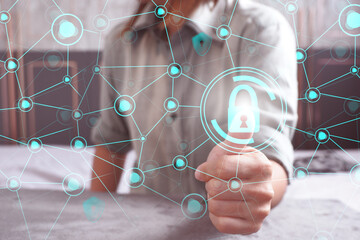 Close-up of a woman's hand pressing on a security system on the security shield icon hologram Data protection concepts and technologies.