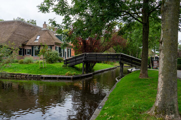 Fototapeta na wymiar Giethoorn Netherlands Venice of the North old farmhouse on the canals with bridge and trees