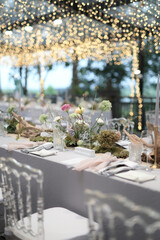 Flowers decoration for wedding or fine dinning table in private party. Family intimacy dinner night outdoors with clear tent