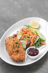 chicken cordon bleu with salad and cranberry sauce
