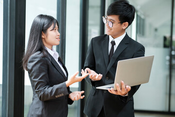 Two businesspeople talking and discussing while standing.