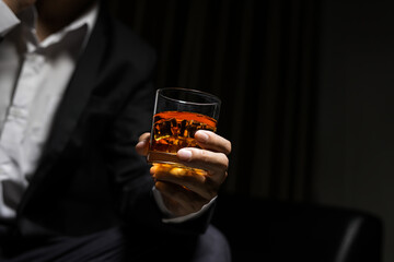 Closeup businessmen holding a glass of whiskey