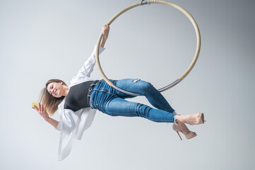 Caucasian female gymnast doing aerial hoop exercises and using smartphone.  © Михаил Решетников