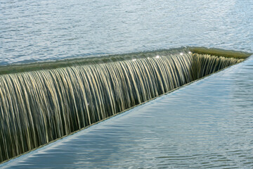 Water flowing in ditch inlet. Weir water stripes pattern,use for background and texture.