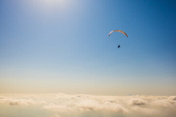 北海道のニセコ上空で曇りよ高く飛ぶパラグライダーを空撮