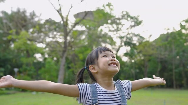 Portrait of young happy asian little girl have fun in the park. take a break and freedom concept. Close up smile face girl. Beautiful little girl 7 years old has lost milk teeth. Loss of milk teeth.