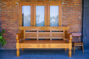 Wooden chairs for guest in the front of window house. Carved chairs vintage style from Indonesia. Traditional chairs for classical interior design. 