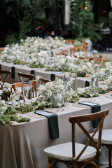 a beautiful wedding decoration arrangement. Table settings. Table Decoration for intimate private party outdoors with fairy light and white flowers. 