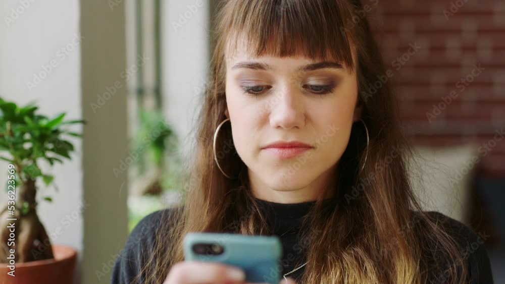 Poster Social media, phone and creative designer reading an email on a mobile app while working at a marketing startup. Face of an employee typing on a chat on the internet with smartphone in an office