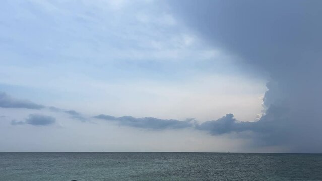 Little redhead girl on beach playing on sea shore with green kite with cloudy and stormy sky in background