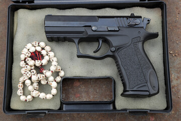 A pistol and rosary in case