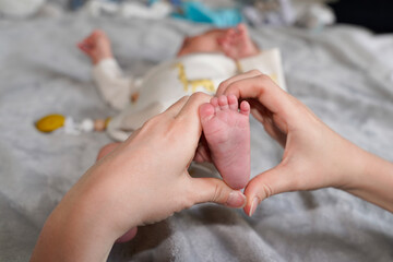 Mother Baby Feet In Heart Shaped Hand in newborn baby Infant Care Concept
