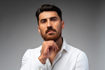 Studuo shot of thinking businessman standing over gray background