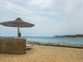 single beach umbrella with a sun lounge at the sandy beach