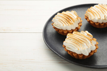 Appetizing lemon cupcakes with white cream on dark plate. Holiday, surprise, birthday, Valentine's Day.