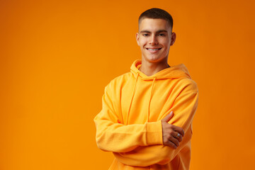 Fototapeta premium Happy smiling young man looking to camera over yellow background
