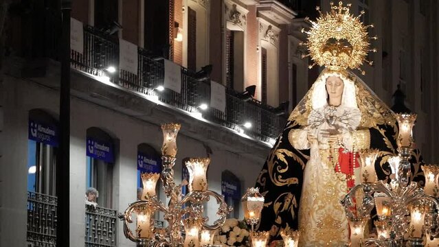 Close-up of procession carriage with Virgin Mary during Holy Week celebrations on Good Friday at Madrid, Spain. Figure is wearing a tunic with golden decoration and a golden crown. Beautiful image.