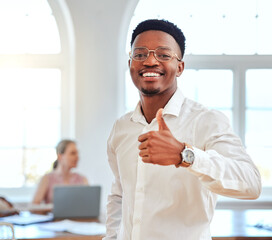 Fototapeta na wymiar Thumbs up, happy and african businessman with a smile standing in his modern company office. Approval gesture, professional and portrait of a a black corporate employee with his thumb up in agreement