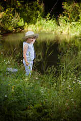 Boy fisherman, catches fish on the river bank in summer