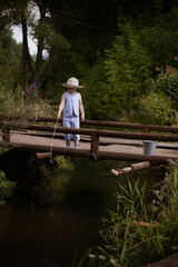 Boy fisherman, catches fish on the river bank in summer