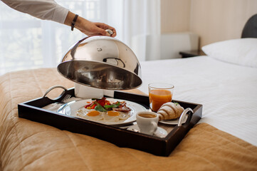 Tasty fresh breakfast with scrambled eggs and vegetables in bed at the hotel room - 536251727
