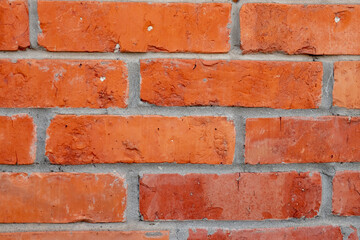 Fragment of old brickwork, close-up. Red brick wall. Potholes and defects in a brick wall. Flat lay, close-up. Cracks and defects of red brick on the wall. building houses, texture
