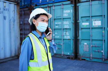 Covid, phone and supply chain logistics with a woman shipping worker on a call while on a commercial container yard. Freight, cargo and communication with a female courier at work with export storage