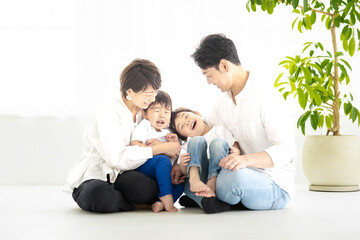 明るい室内ではしゃぐ家族 