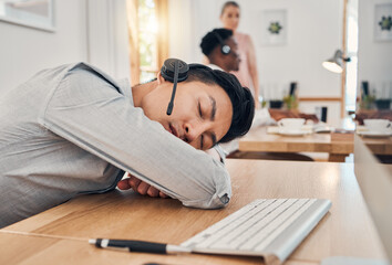 Tired call center worker sleeping at desk, burnout from working at telemarketing company and stress...