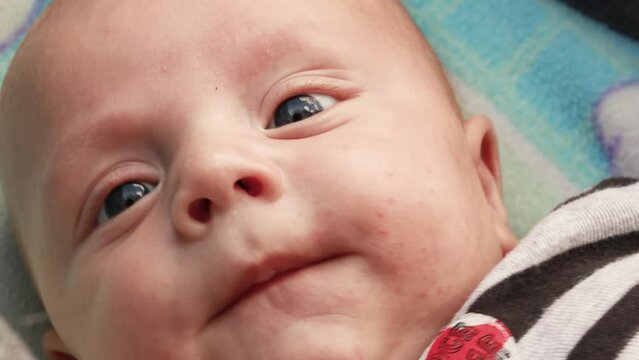 4k footage video. Close up newborn baby child lying in baby carriage stroller buggy having fun playing, looking at her mother, smiling infant. Outside walking in pushchair, fresh air

