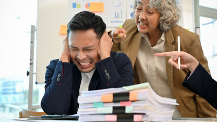 Angry and mad senior female boss is yelling at her male employee.