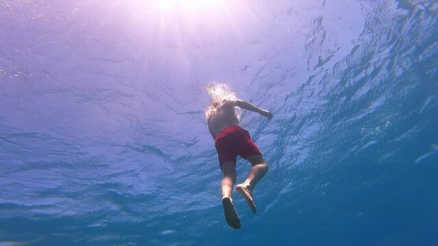 a young swimmer rises to the surface of the Mediterranean Sea, vacation, warm water and scuba diving