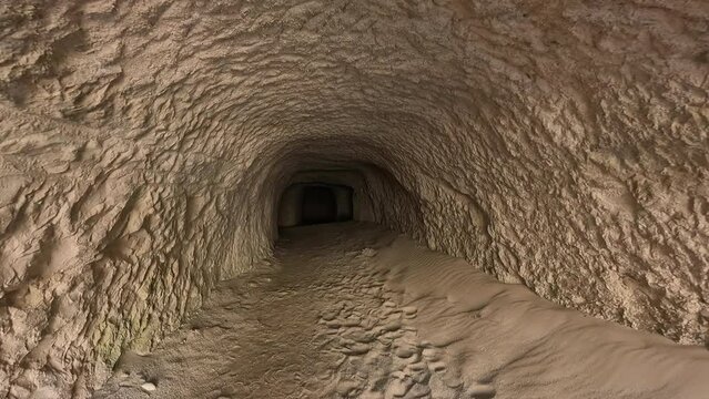 View of a small tunnel with a dark enf, sharp rocks construction