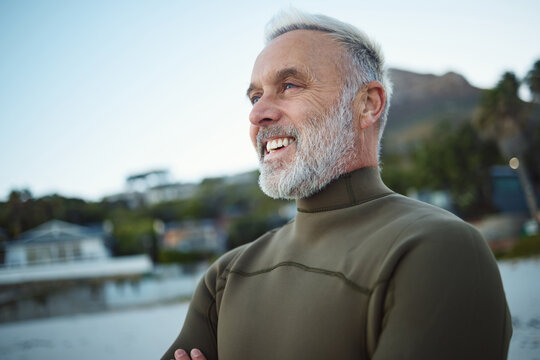 Surf, happy and senior man at the beach for peace, calm or freedom of the mind during holiday in Rio de Janeiro Brazil. Wetsuit, retirement sports and elderly person relax before surfing for wellness