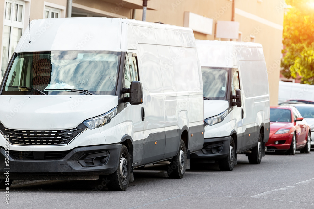 Wall mural small cargo delivery van parked in european city central district. medium lorry minivan courier vehi