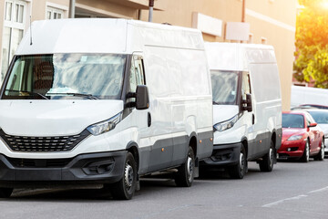 Small cargo delivery van parked in european city central district. Medium lorry minivan courier vehicle deliver package at residential office building in downtown area. Commercial shipping logistics