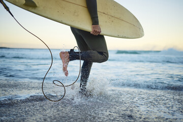 Beach, surf board and surfer man walking in water, sports and fitness on weekend evening. Freedom,...