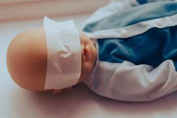 baby doll with taped eyes. child abuse concept