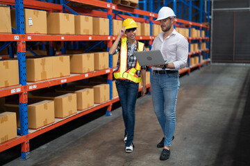 Supervisor and manager smiling happy holding laptop computer on hand visit warehouse annual audit...
