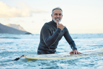 Senior man surfing in Hawaii beach, surf culture hands signal and healthy fitness in ocean nature....