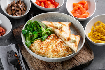 Omelet with spinach and toast on a plate. Scramble eggs with various toppings for breakfast