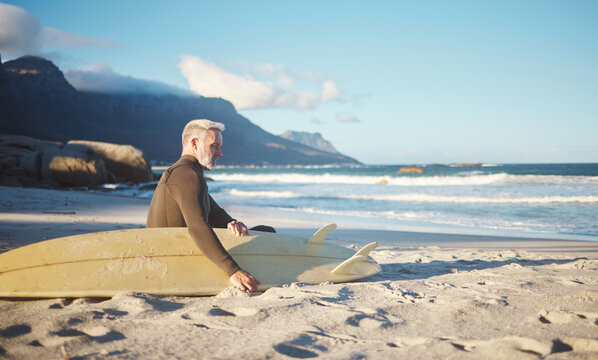 Surf, relax and senior man on the beach for sports, surfing and fun exercise for health, wellness and ocean sea freedom. Peace, sand and surfer chill after fitness or surf board training in Portugal